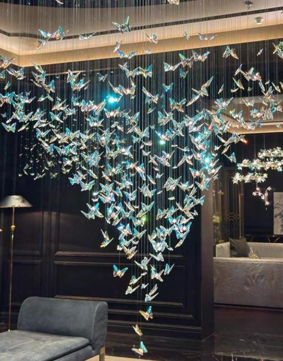 Suspended glass butterfly installation in a double-height living room